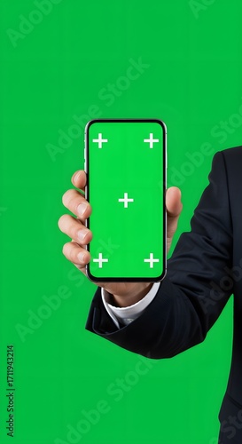 photo of a businessman holding a smartphone with a green screen display, background fully green screen