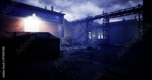 Faded structures stand abandoned under a cloudy sky, with one bright light illuminating parts of the derelict warehouse. The atmosphere carries a sense of desolation and mystery.
