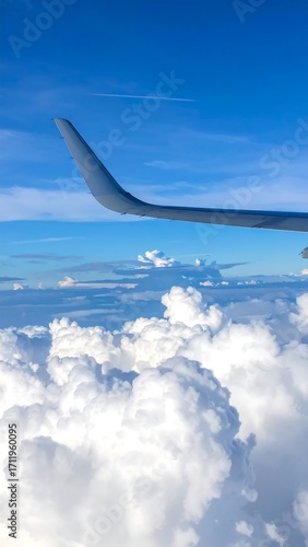 Airplane wing over fluffy clouds