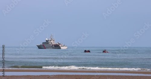 Sangatte, France – June 11, 2025: Migrants attempting to cross the English Channel on small boats, accompanied by a French customs vessel.
