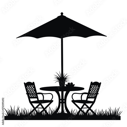 Outdoor patio table chairs and umbrella silhouette on grass