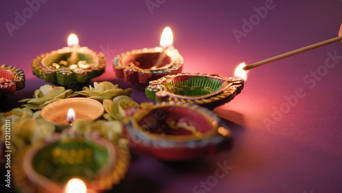 hand igniting festive Diwali diyas