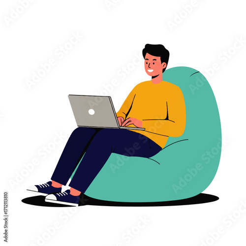 A young man sits comfortably in a beanbag chair, working on a laptop with a smile on his face.