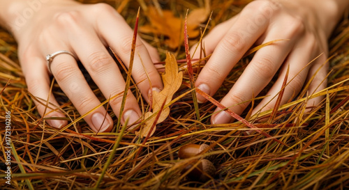 Elegant Hands Resting Among Autumn Grasses and Fallen Leaves with a Subtle Wedding Ring Detail Captured in Warm Natural Light
