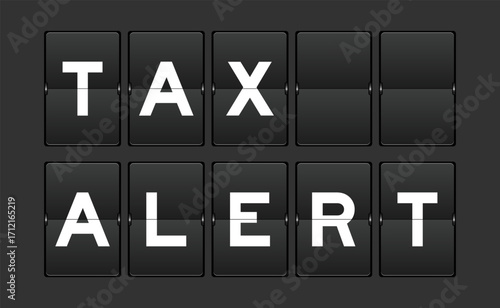 Black color analog flip board with word tax alert on gray background