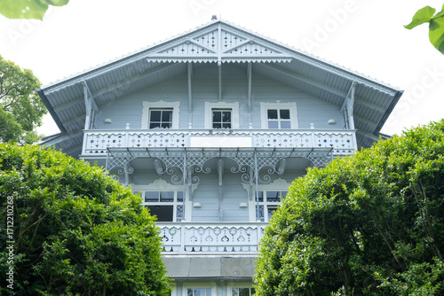 Historic seaside villa with ornate wooden balcony and decorative architecture