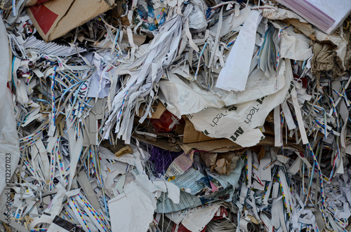 A detailed, abstract close-up of a pile of shredded paper and cardboard scraps collected for recycling. The image highlights the recycling process and sustainability efforts.
