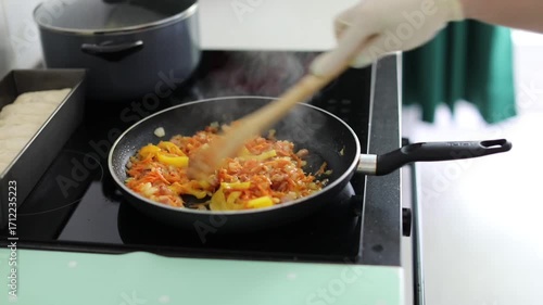 Woman frying veggies for stew at home