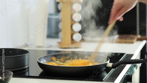 Woman frying veggies for stew at home