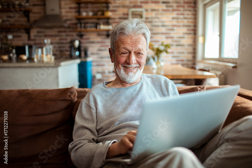 Senior man using laptop at home