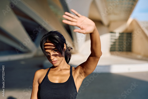 Foto Sportswoman shielding her face from the bright sunlight with her hand while enjo