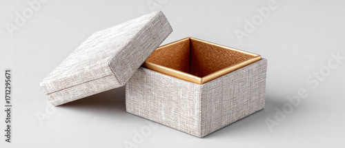 Small textured jewelry box with removable lid and gold interior, photographed on neutral background conveying elegant presentation and delicate storage for rings and small keepsake