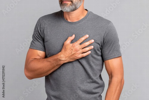 Man placing hand on chest male torso with hand over heart gray t shirt bearded man gesture emotional expression of gratitude or pain mid adult male