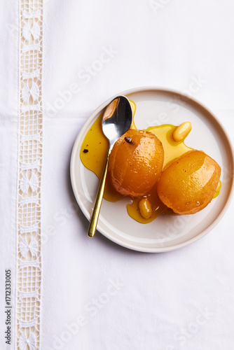 Tableau sur toile firiki spoon sweet on a white plate with spoon on a white tablecloth