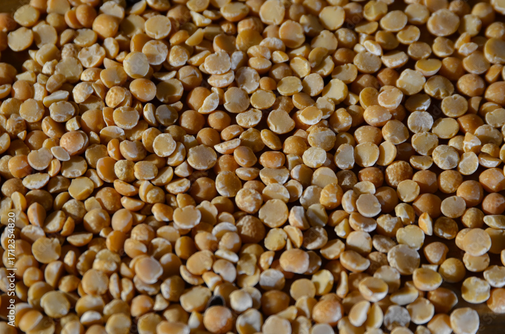 Fototapeta premium A seamless texture background made of dry yellow peas scattered across the surface. Natural organic food backdrop, healthy eating and cooking ingredient.