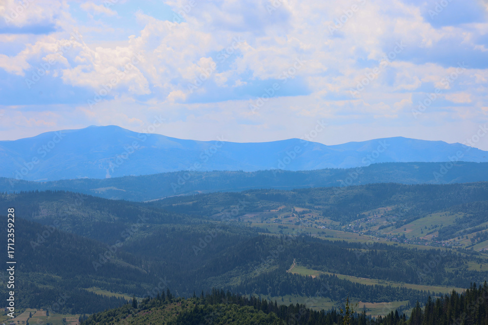 Fototapeta premium A majestic mountain range that melts into the blue haze on the horizon creates an impressive landscape that conveys the boundlessness of space and tranquility.