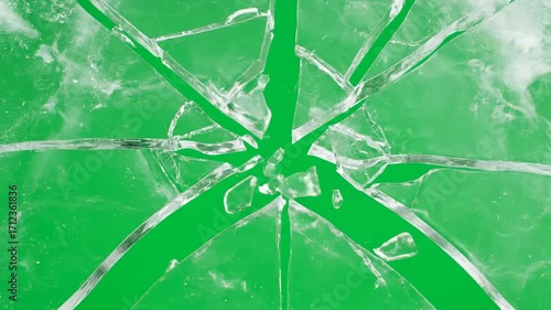 A sheet of ice cracking and shattering into many pieces, isolated on a solid green screen element, force, winter