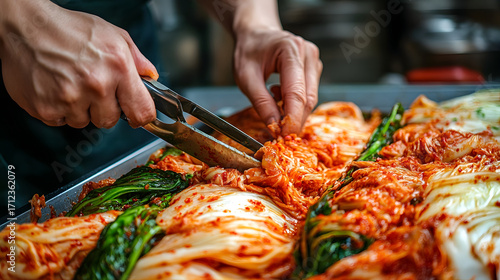 Hands cutting freshly made kimchi with kitchen scissors, showcasing vibrant colors and textures in traditional Korean dish. scene captures essence of culinary art