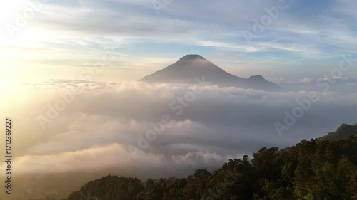 Cinematic drone flight over fluffy clouds with a mountain on the horizon