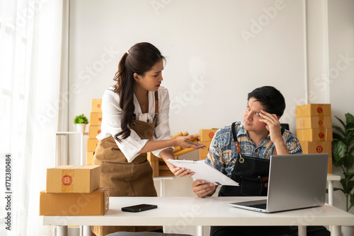 Online sellers having problems with orders in warehouse, woman pointing at clipboard