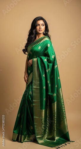 Elegant indian woman wearing a beautiful traditional green silk saree with a golden pattern