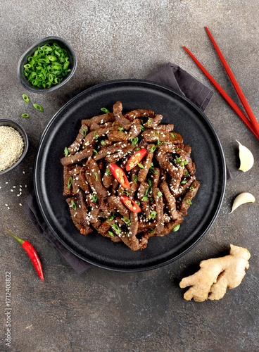 Asian teriyaki beef strips with spice, sesame on a gray background. Top view. Asian food.