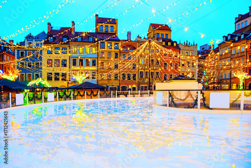 Enchanting Old Town Market Square in Warsaw, Poland, festive ice rink surrounded by historic buildings with dazzling Christmas lights. Magical atmosphere of Warsaw Old Town during the holiday season