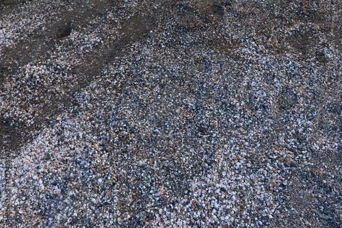 Photos Close ground view of wet beach granules with a diagonal band marking the compacted swash zone