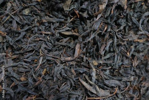 Photos Loose black tea leaves form a dense layer with twisted strands and occasional golden tips