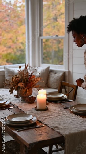 African American Woman Prepares an Inviting Autumn Table with Lit Candles for a Festive Meal