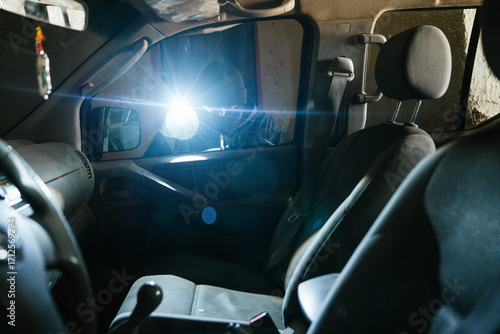 Thief stealing a vehicle with a flashlight and a screwdriver in a dark place