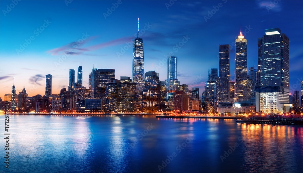 Obraz premium a vibrant city skyline at dusk showcasing modern skyscrapers illuminated against a deep blue sky a stunning blend of architecture reflecting urban life and modernity