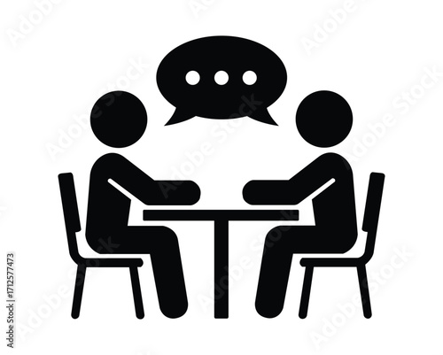 Two black stick figures discuss ideas at a table, with a white background