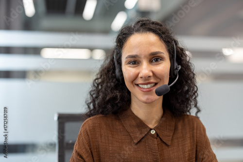Tableau sur toile Customer service operator with headset smiles confidently at camera in modern of