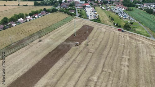 Aerial drone footage of a combine harvester cutting a golden wheat field, showcasing modern agriculture, grain harvest, rural landscape, and seasonal farming productivity.
