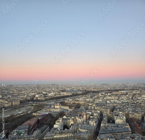 Panoramic city skyline at dusk with pastel sky and river