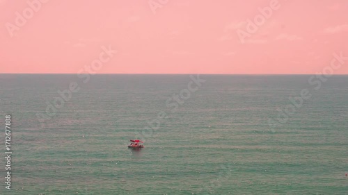 Colorful Sunset Clear Pink Sky with Puffy Clouds over Blue Sea, Time Lapse. Beautiful Sunrise Pink Sky and Ocean, Seascape 4K. Aerial View Sea Horizon Part Sky Cloud Part Blue Sea and Catamaran.