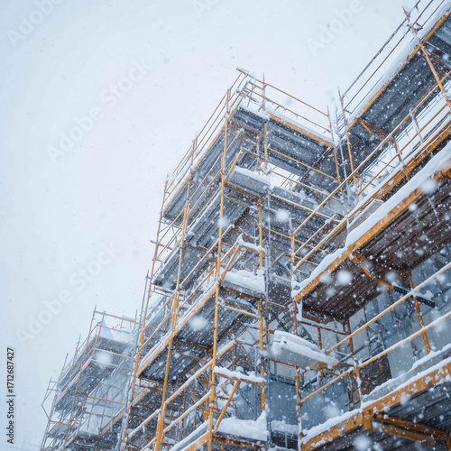 Snow-covered scaffolding. Winter construction site background for building, architecture, and industrial themes