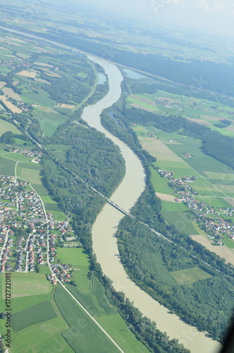 Stunning aerial view of a vibrant valley surrounded by majestic mountains in summer with blue skies, Salzburg Valley, Austria. Salzach river drone view.