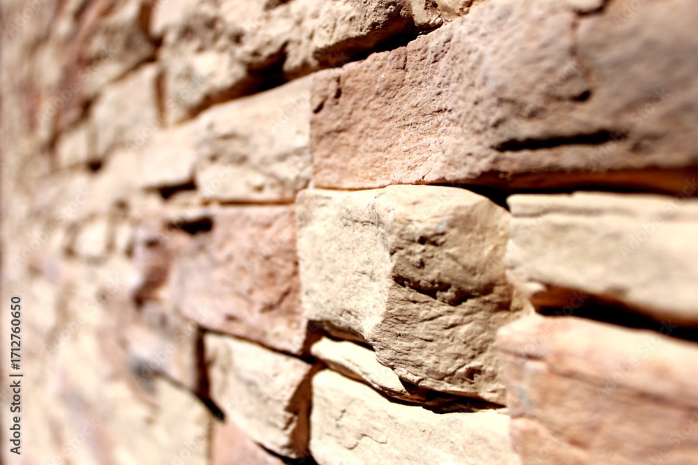 Fototapeta premium Stone wall texture close-up Detailed close-up of a decorative stone wall with natural colors and textures. Perfect for use as a background, design element, or architectural concept.