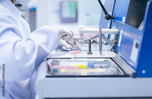 Laboratory technician conducting analysis with advanced equipment in a clean room environment during work hours