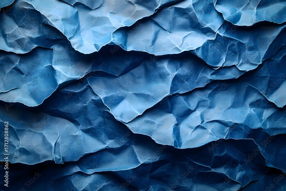 Fototapeta premium Close up of heavily crumpled blue paper creating a textured and layered abstract pattern