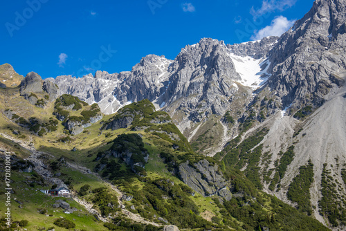 Wallpaper Mural Alps mountains scenic landscape in summer. Austrian Alps scenery trekking path among the high mountain peaks in summer. Green mountain valleys with rocky peaks and lake in the Alps in Austria Torontodigital.ca
