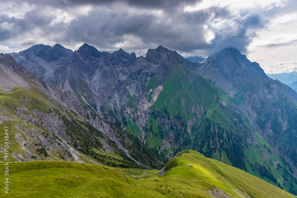 Fototapeta premium Alps mountains scenic landscape in summer. Austrian Alps scenery trekking path among the high mountain peaks in summer. Green mountain valleys with rocky peaks and lake in the Alps in Austria