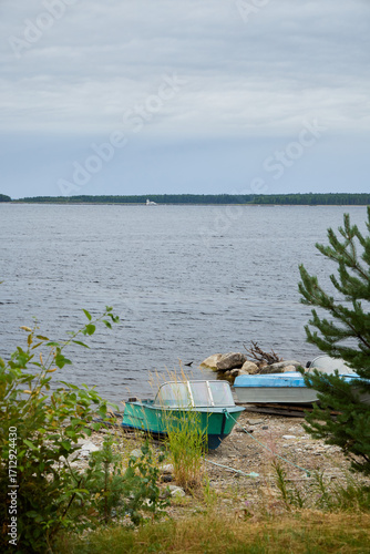 A Serene Lakeside View Featuring Boats Gently Floating on Calm Waters Reflecting the Sky
