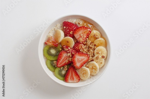 Healthy breakfast recipe featuring homemade oatmeal porridge topped with fresh strawberries, bananas, and kiwi, rich in vitamins and antioxidants.