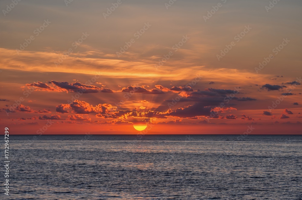 Fototapeta premium Evening sky with clouds reflecting on the water surface