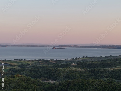 Aerial view of Bisentina Island on Lake Bolsena at dusk
Scenic drone photo of Bisentina Island in Lake Bolsena, captured at dusk with soft pink sky and calm waters.