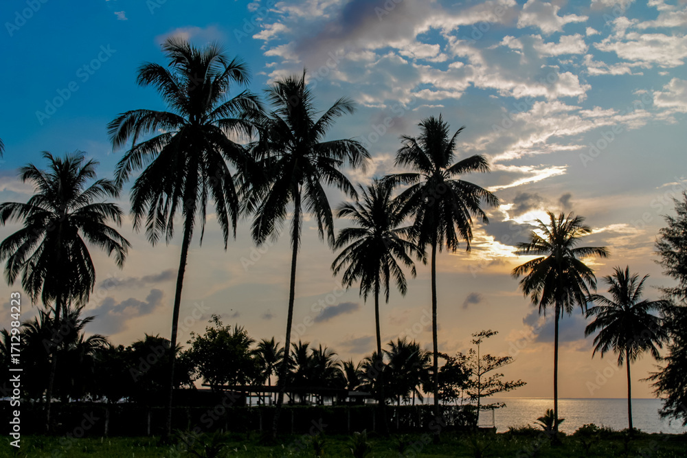 Fototapeta premium Cliffs, palm trees and sandy beach in Krabi, Thailand, with turquoise sea, limestone formations, and tropical vegetation under clear sky, showing coastal landscape travel destination in Andaman sea