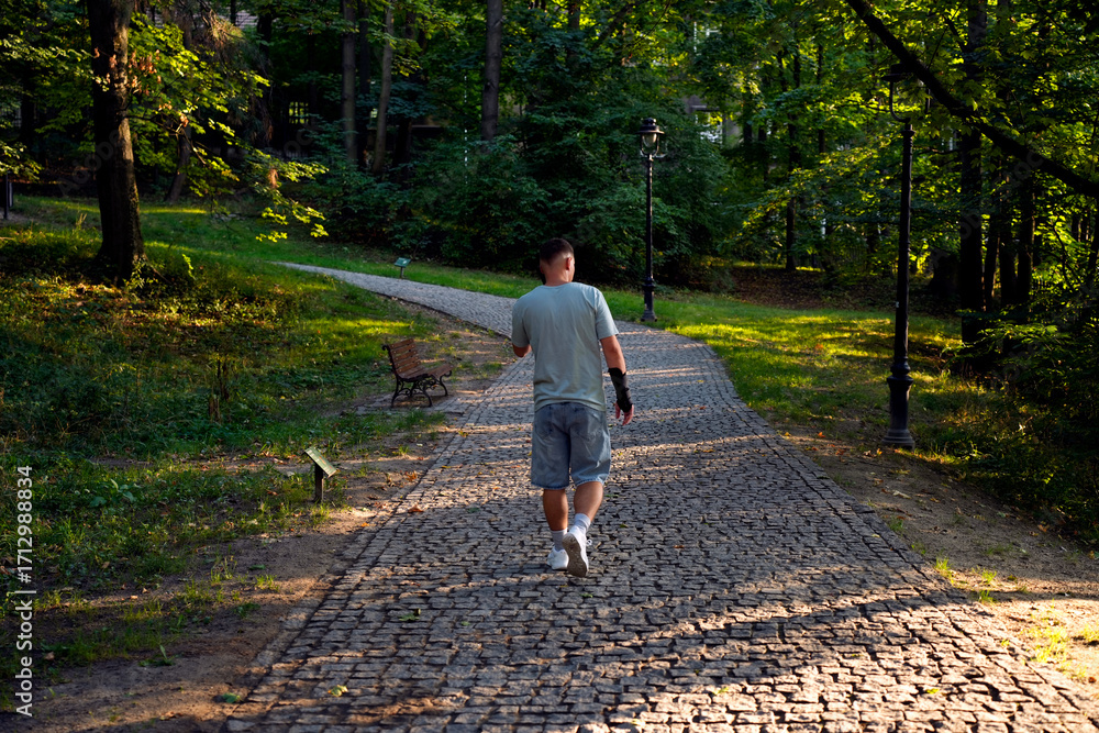 Fototapeta premium Man walking on park path